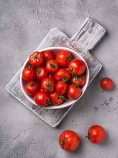 Ciotola di pomodori maturi freschi su tagliere