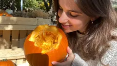 Ragazza con zucca intagliata in un ambiente all'aperto autunnale