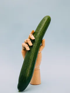 Persona con zucca verde e mano artificiale in posa
